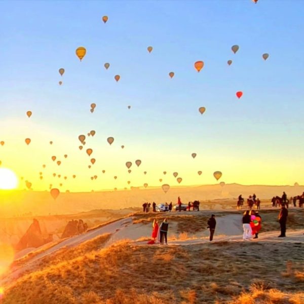 Cappadocia hot air balloon panorama view at sunrise with balloons flying over fairy chimneys