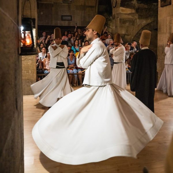 Whirling Dervish Ceremony in Cappadocia Whirling dervishes performing the spiritual Sema ceremony in a traditional Cappadocian setting.