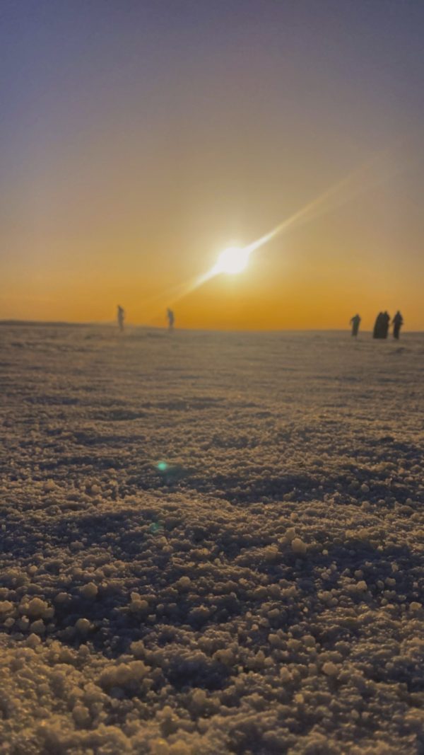 Salt Lake Tour – The Mirror of the Sky A couple walking on the reflective white surface of Salt Lake during sunset, creating a dreamy mirrored scene.