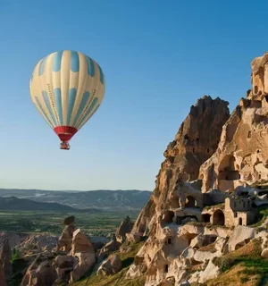 Colorful hot air balloons flying over the fairy chimneys of Cappadocia at sunrise.